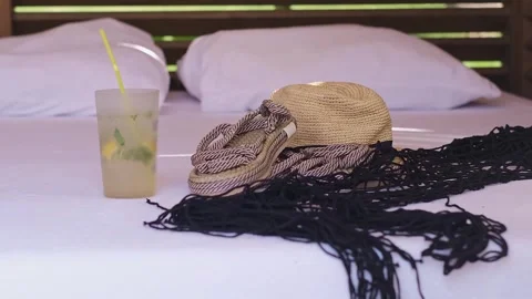 Straw hat, flip-flops, and cocktail glass: essentials for seaside resorts, beach Stock Footage 270084939