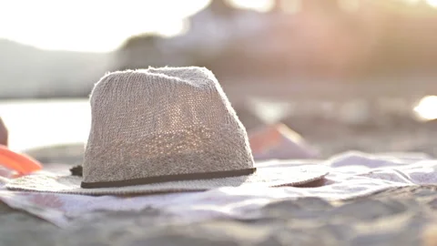 Straw hat flops on a tropical beach. Girl takes a headdress. Stock Footage 115305322