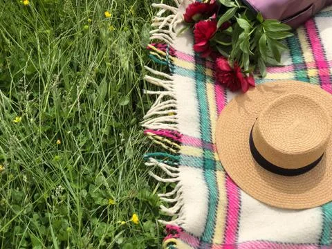 Straw hat with flowers. Backpack with red flowers inside. blanket close-up. Stock Photos