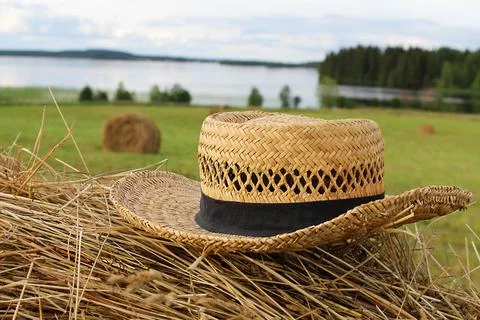 Straw hat on a haystack in a field close-up. Summer mood Stock Photos