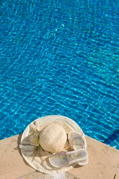 The straw hat lies on the brink of pool Stock Photos