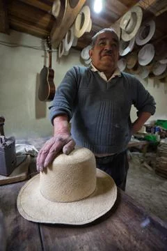 Straw hat maker man with a finished hat Stock Photos