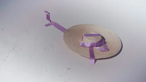 Straw hat with a pink ribbon on white sand. Stock-Footage 128943194