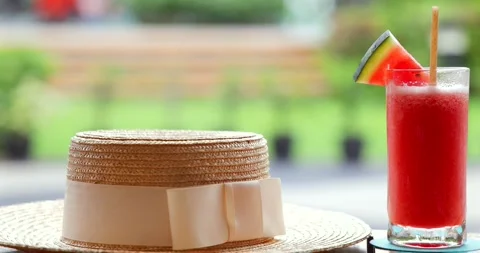 Straw hat resting on table beside refreshing watermelon smoothie Video stock 312000252