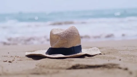A straw hat rests on the beach, evoking visions of seaside resorts and eco-frien Stock Footage 270084973