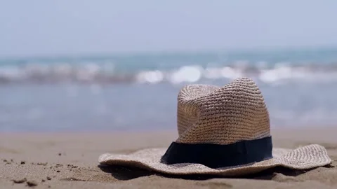 A straw hat rests on the beach, evoking visions of seaside resorts and eco-frien Stock Footage 270084977