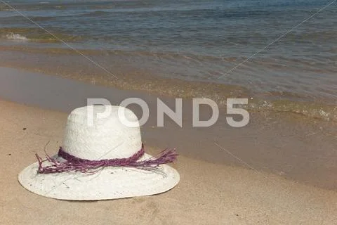 Straw hat on a tropical beach summertime Stock Photos