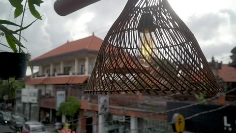 A straw lampshade hanging rotates in the background of a Bali Ubud house Stock Footage 126971044