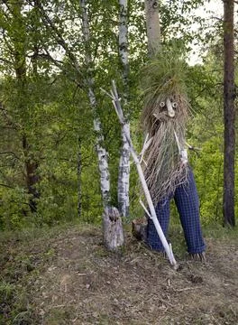 Straw man in the forest. The puppet is made of straw, grass, branches Stock Photos