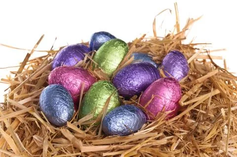 Straw nest with chocolate easter eggs Stock Photos
