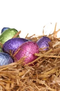 Straw nest with chocolate easter eggs Stock Photos