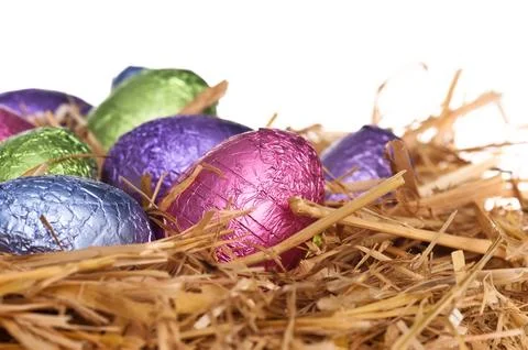 Straw nest with chocolate Easter eggs Stock Photos