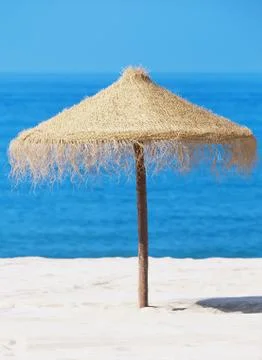 Straw parasol on beach Stock Photos