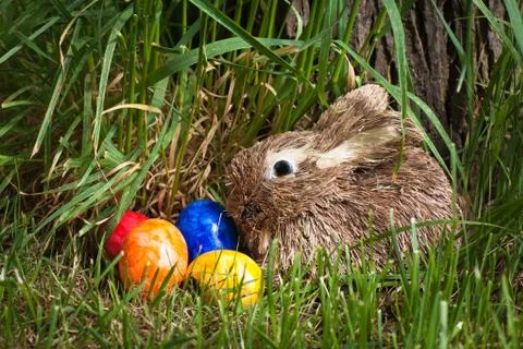 Straw rabbit and easter eggs Stock Photos