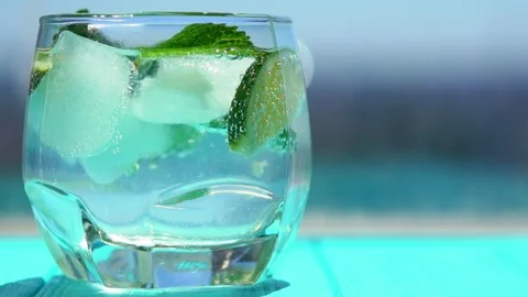 Straw stirring ice cubes and citrus fruit slices Stock Footage 94054237