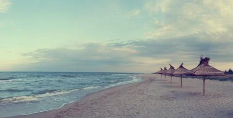 Straw umbrellas on beach Stock Photos