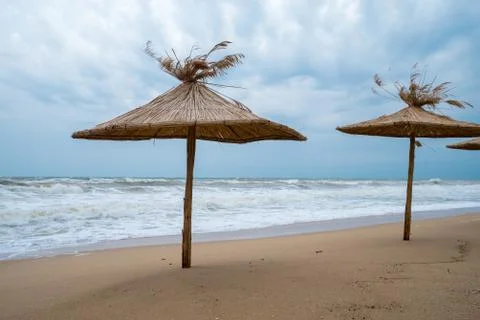 Straw umbrellas on the beach. Stock Photos