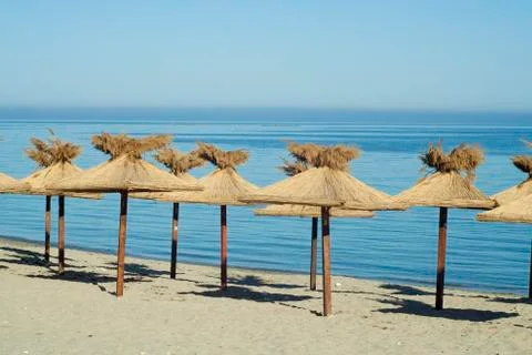 Straw umbrellas at the beach Stock Photos