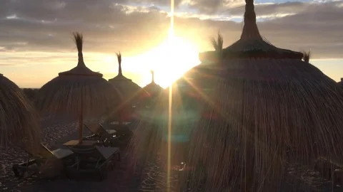 Straw umbrellas in evening with sunset in Costa Adeje Tenerife Spain Video stock 80066440