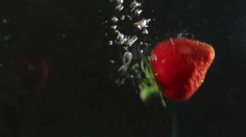 A strawberrie falling in water Stock Footage 24896751