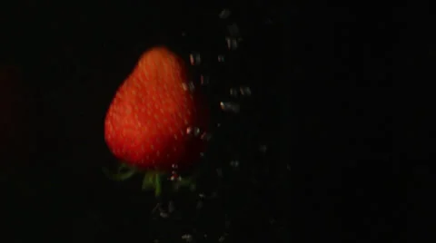 A strawberrie falling in water Stock Footage 24898453