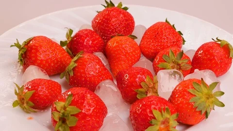 Strawberries and ice cubes watered with melted chocolate on top. Stock Footage 101583444