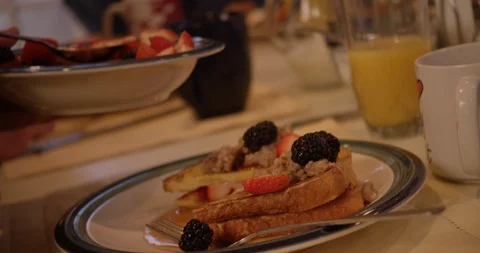 Strawberries and raspberries being spooned over freshly made french toast Video stock 123737513