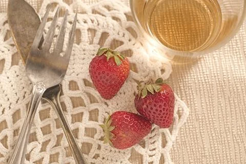 Strawberries and silverware on the table. Stock Photos