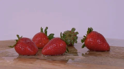 Strawberries being dropped while Rotating over white background, Strawberries Video stock 127985774
