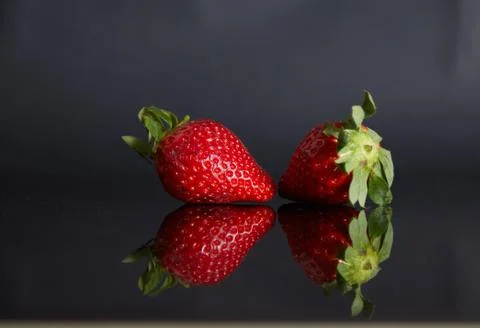 Strawberries on a black background with reflection Stock Photos