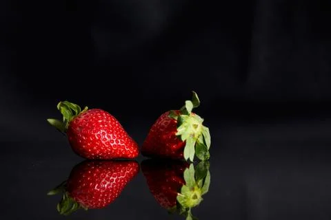 Strawberries on a black background with reflection Stock Photos