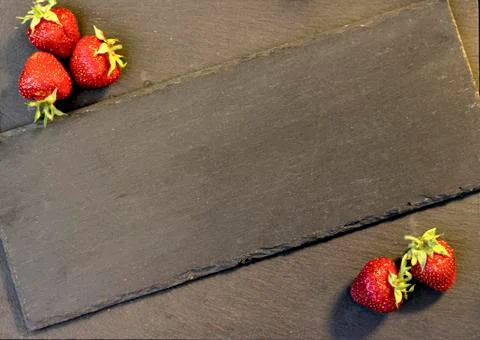 Strawberries on a black graphite background Stock Photos