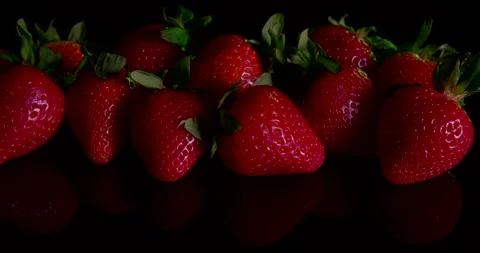 Strawberries on a black table in a studio Stock Footage 243293955