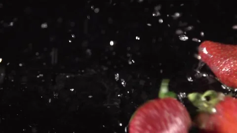 Strawberries Dropping in Water on a Black Background Stock Footage 201237028
