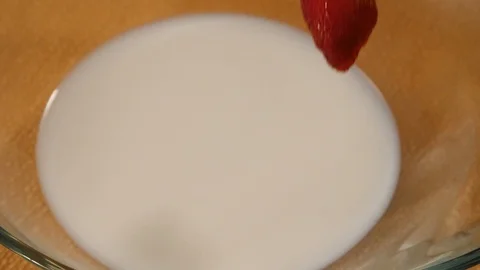 Strawberries fall into milk in slow motion Stock Footage 112887564