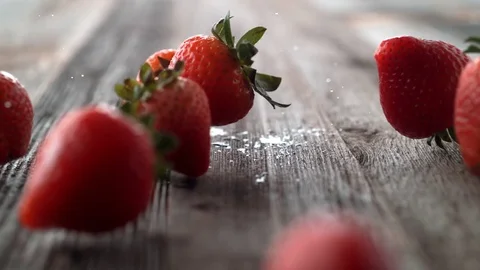 Strawberries falling and rolling on a table. Slow Motion. Stock Footage 84927192