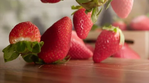 Strawberries falling in slow motion over wood table Stock Footage 156202832