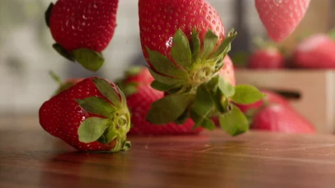 Strawberries falling in slow motion over wood table Stock Footage 156202863