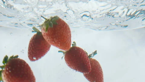 Strawberries falling into the water with bubbles in an aquarium 120 fps Stock Footage 101686275