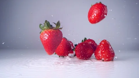 Strawberries falling on water surface. Slow Motion. Stock Footage 128771369