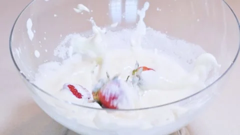 Strawberries falling into yogurt Stock Footage 130529491