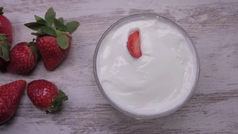 Strawberries falling in yogurt slow motion Stock Footage 150454968
