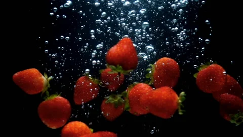 Strawberries float in the water in slow motion. Stock Footage 201931017