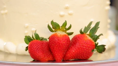 Strawberries in front of elegant vanilla wedding cake Stock Footage 120407212