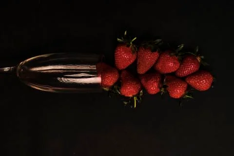 Strawberries in glass on black background, slightly underexposed Stock Photos