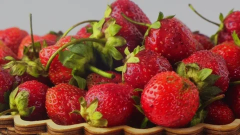 Strawberries with green leaves rotating in a circle on a white background. .. Stock Footage 285652885