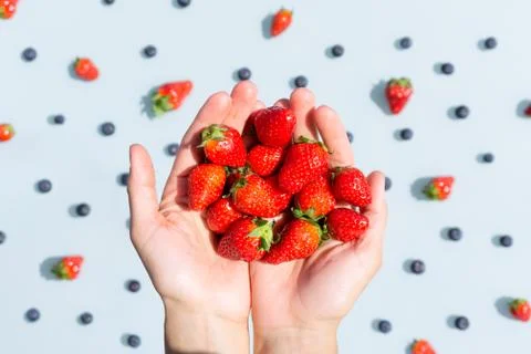 Strawberries in hands. Close up. Fruit pattern. Top view Stock Photos