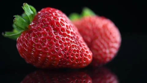 Strawberries isolated on a black background. Two Fresh ripe strawberries Stock Footage 233591487