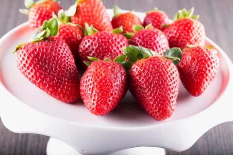 Strawberries over white riser Stock Photos