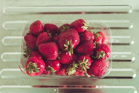 Strawberries in the package on the table Stock Photos